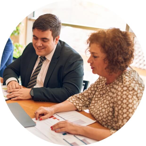 Professional man and woman working on a laptop at a conference room table